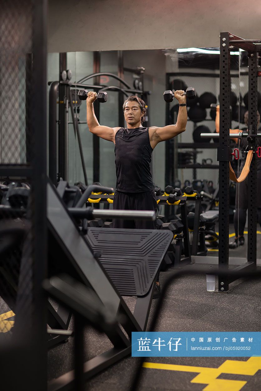 成熟男士在健身房举哑铃