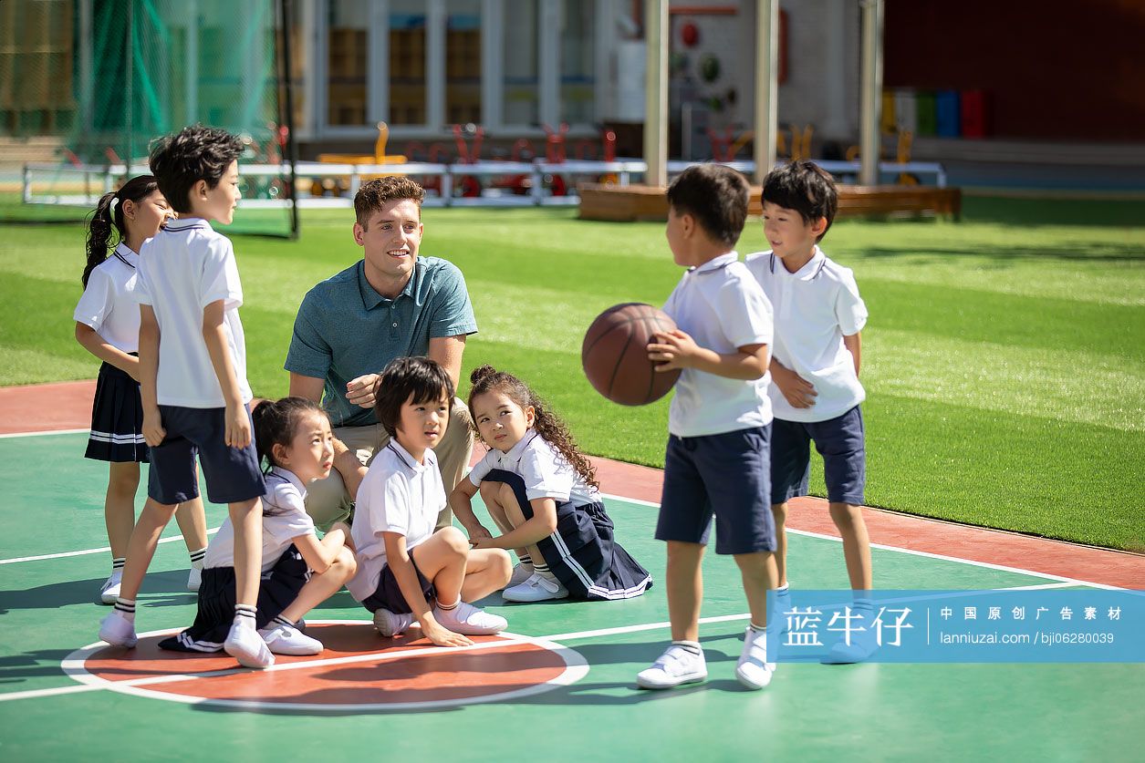 外教和孩子在操场打篮球