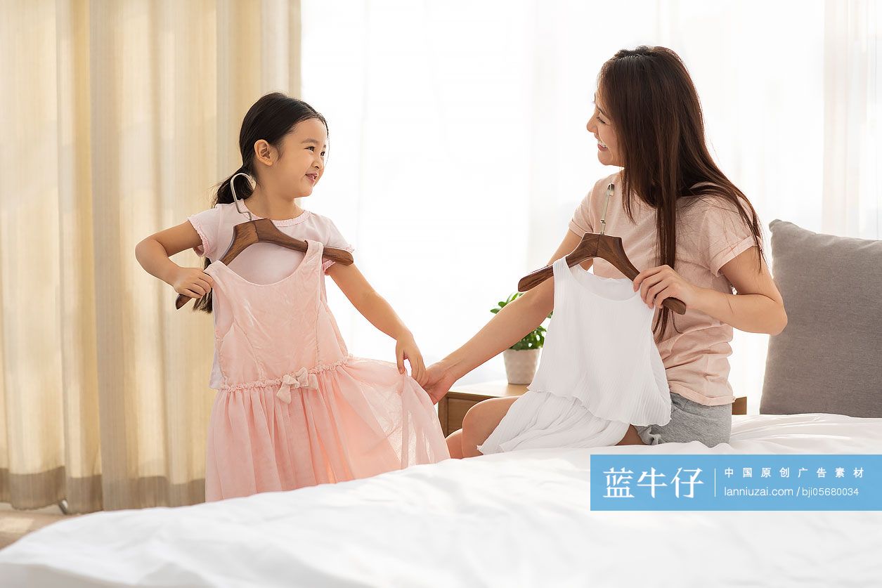 母亲在卧室帮女儿挑衣服