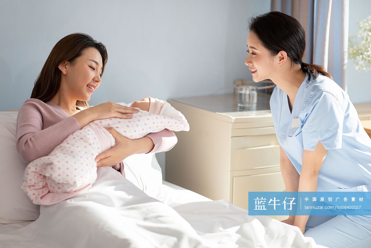 年轻的母亲在病房抱着刚出生的婴儿