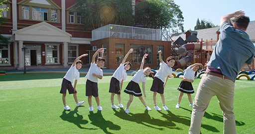 Teachers and students exercising in kindergarten playground,4K