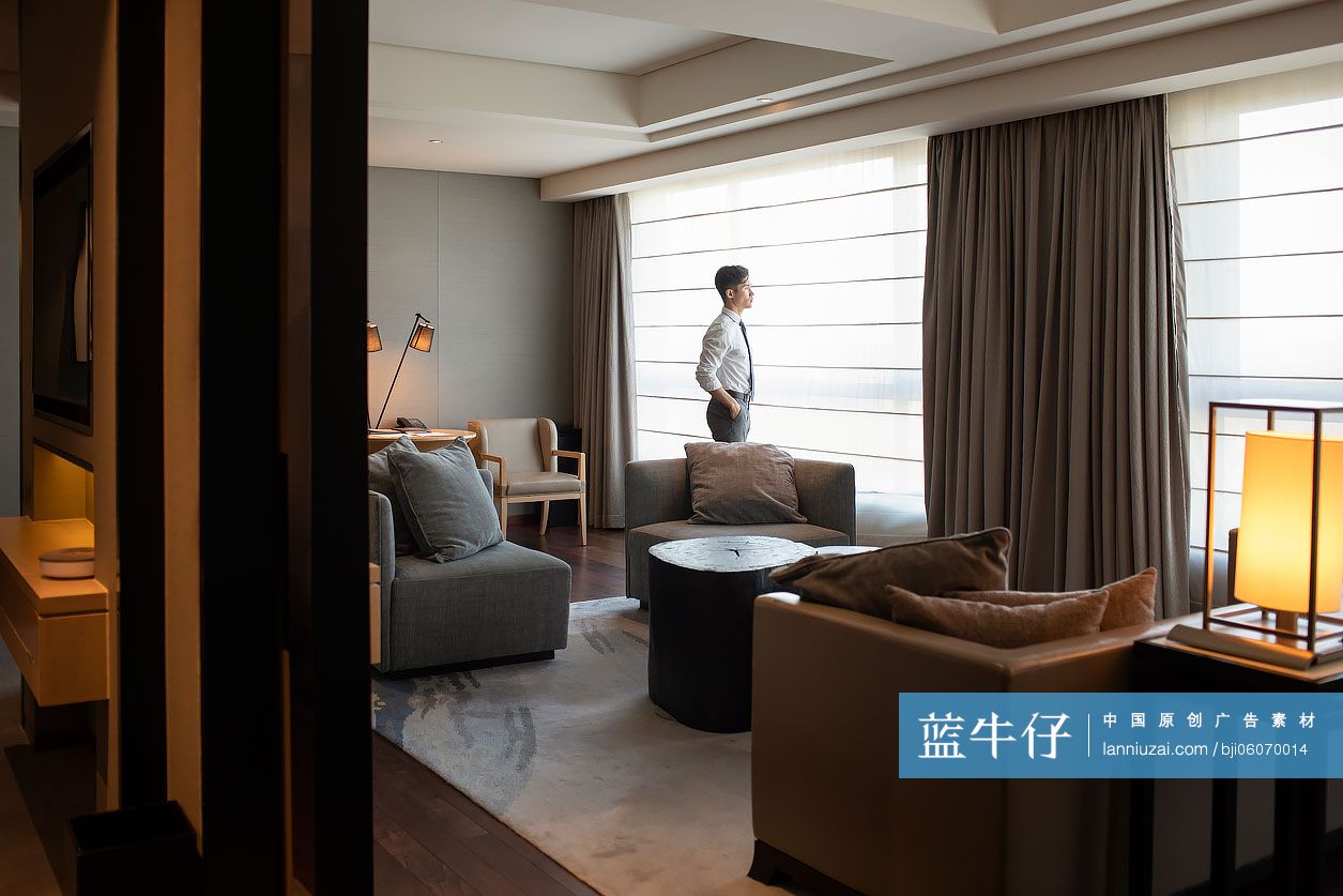 年轻商务男士在酒店窗前思考-蓝牛仔影像-中国原创广告影像素材