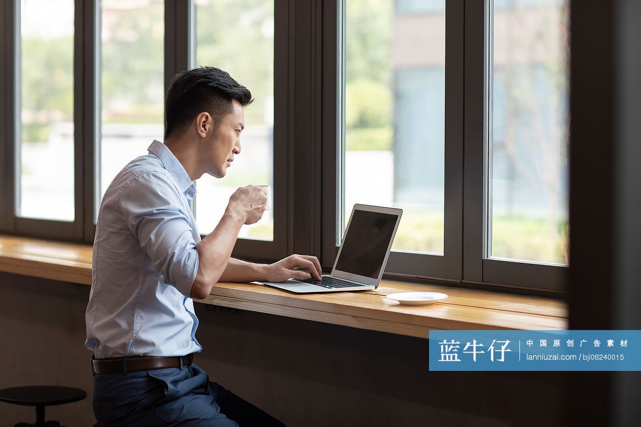 商务男子在咖啡馆使用笔记本电脑工作