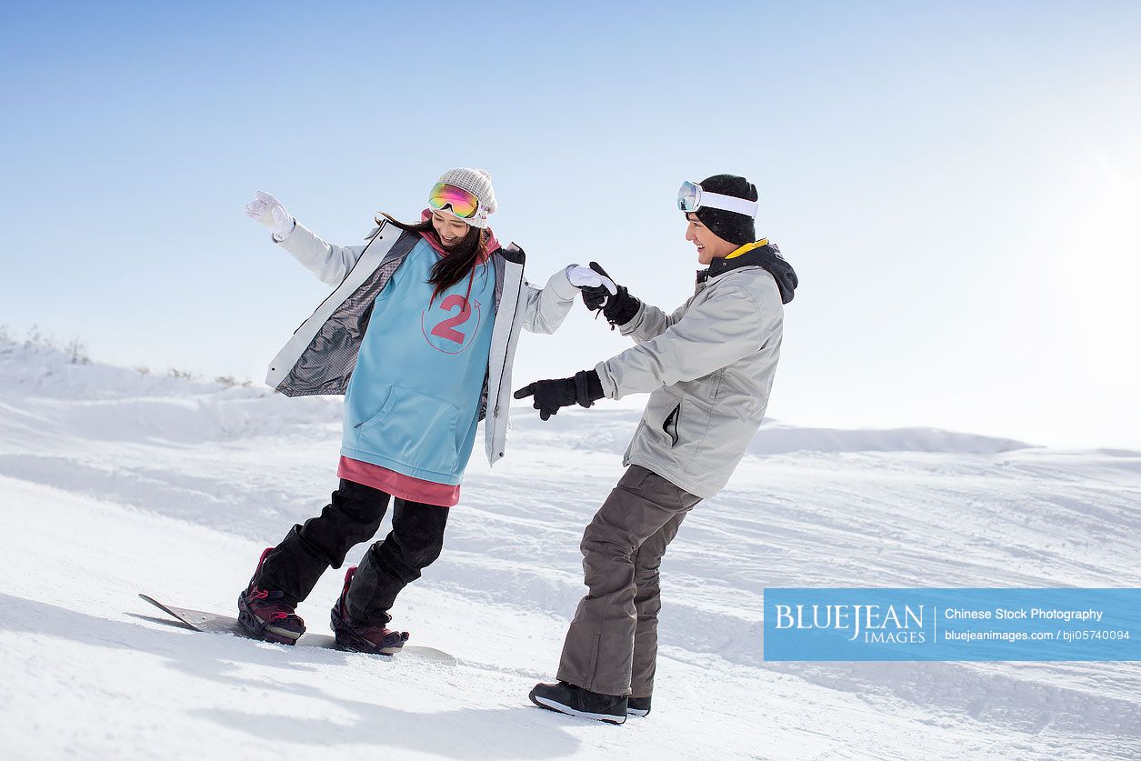 Happy young couple skiing in ski resort