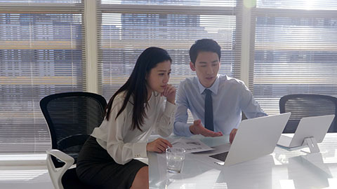 Young Chinese business people using laptop in office,4K