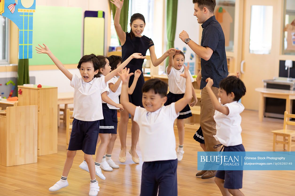 Teachers and children playing in classroom