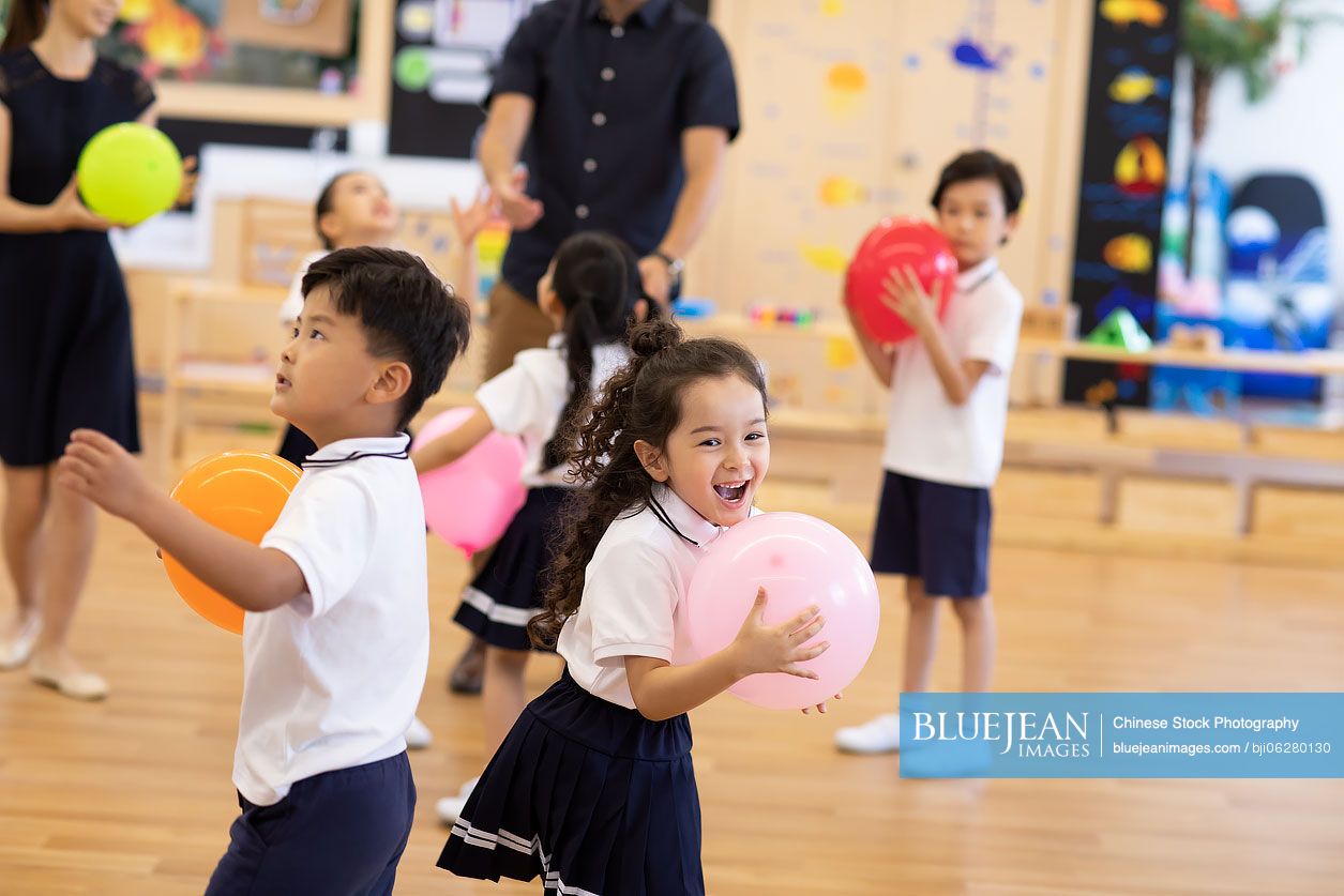 Teachers and children playing in classroom