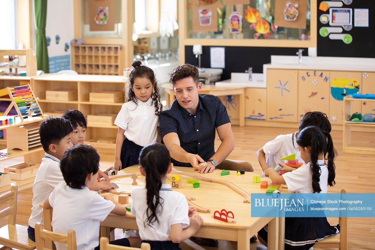 Foreign teacher and children playing in classroom