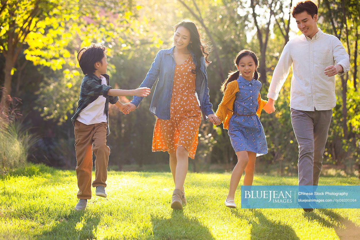 Happy young Chinese family having fun in park