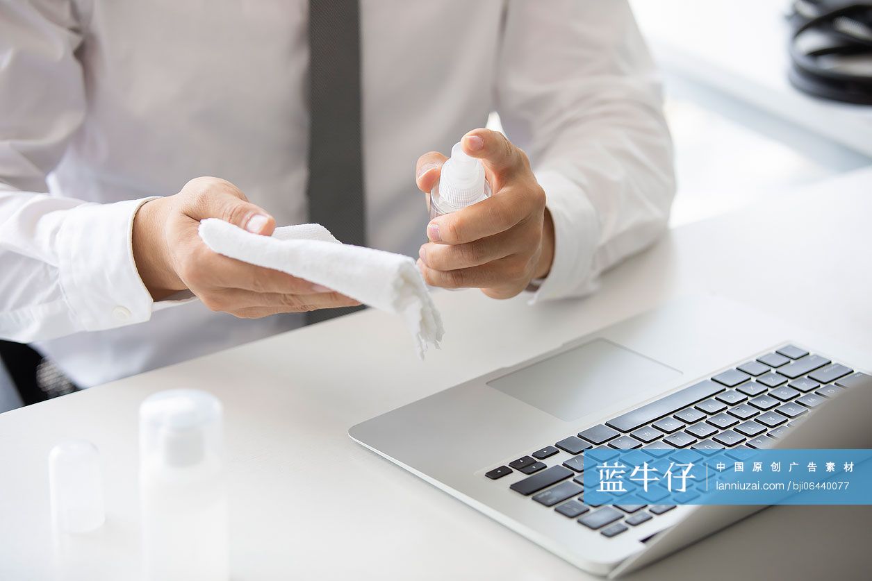 年轻的商务男士在办公室使用消毒液杀菌消毒