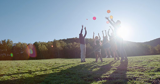 快乐的的六口之家在草地上玩气球