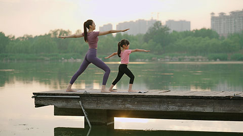 妈妈和女儿在公园练瑜伽