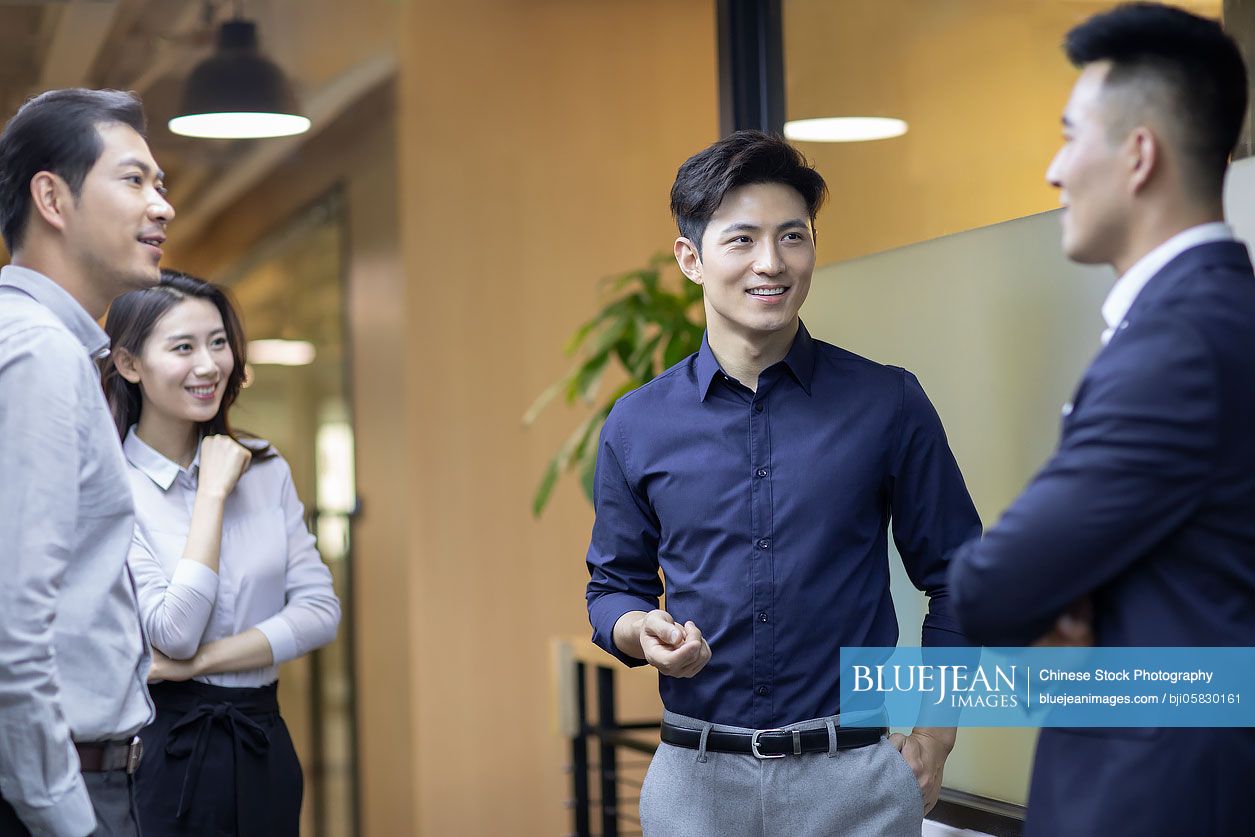 Confident Chinese business people talking in the corridor