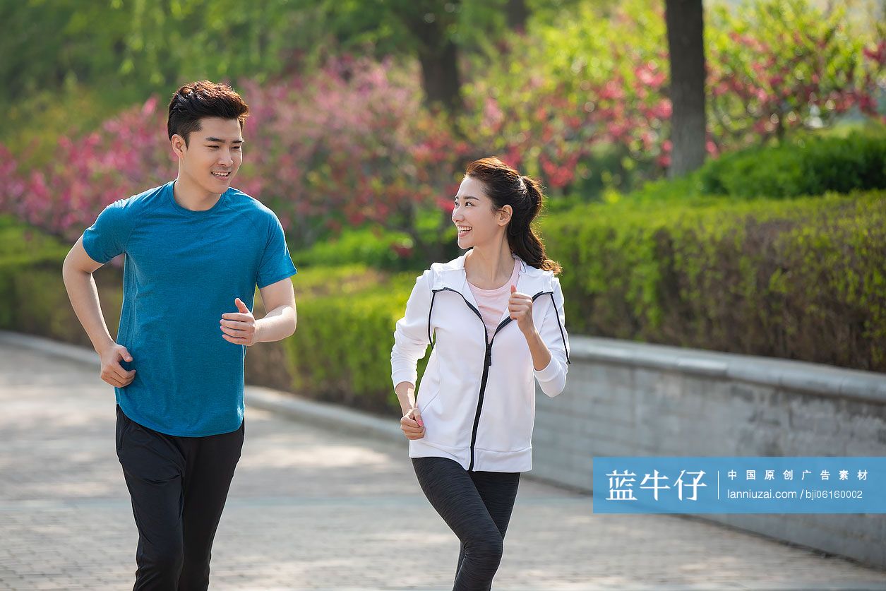 快乐的年轻情侣在公园跑步