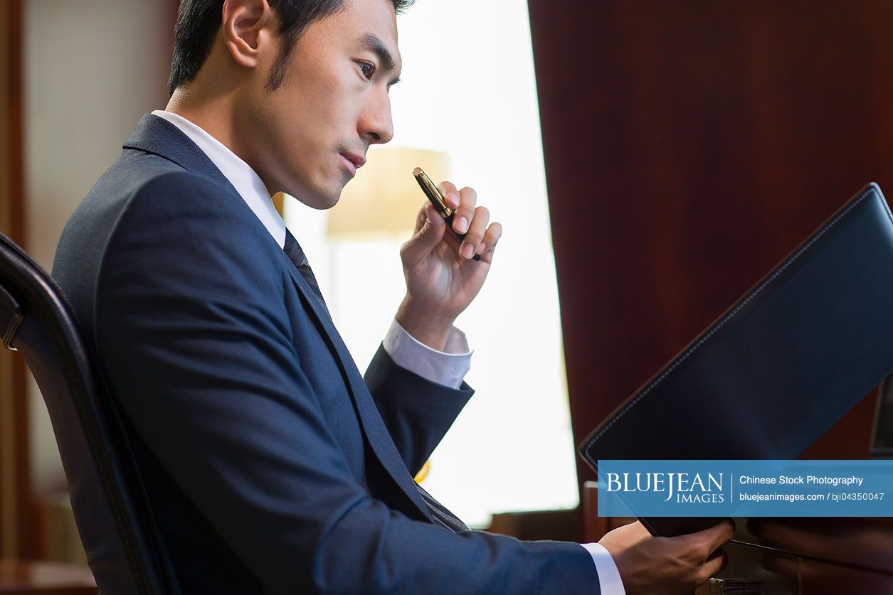 Successful Chinese businessman working in study