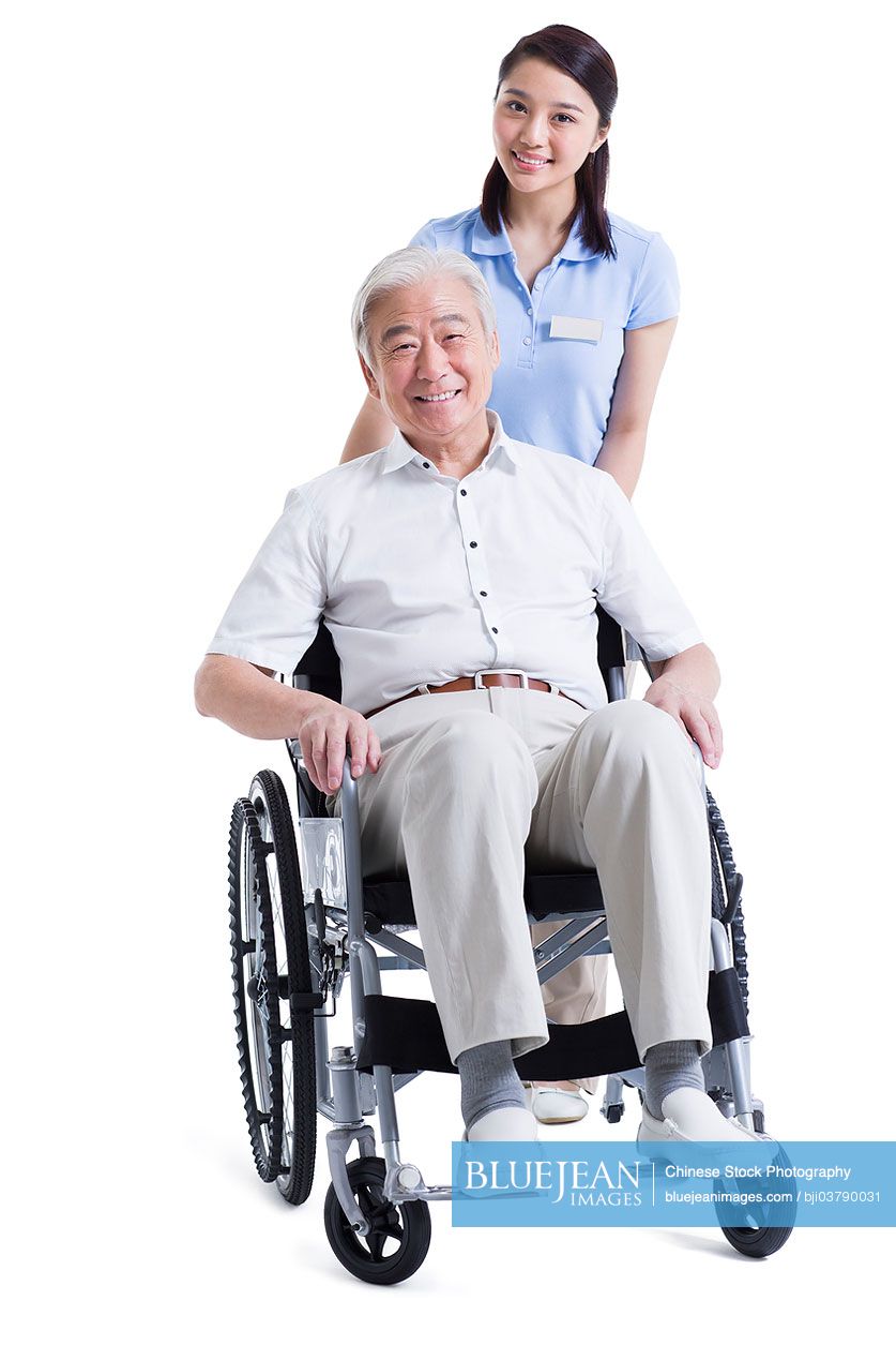 Chinese female nursing assistant taking care of senior in wheelchair