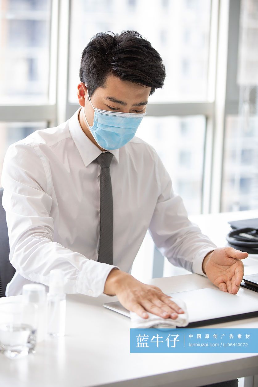 年轻的商务男士在办公室使用消毒液杀菌消毒