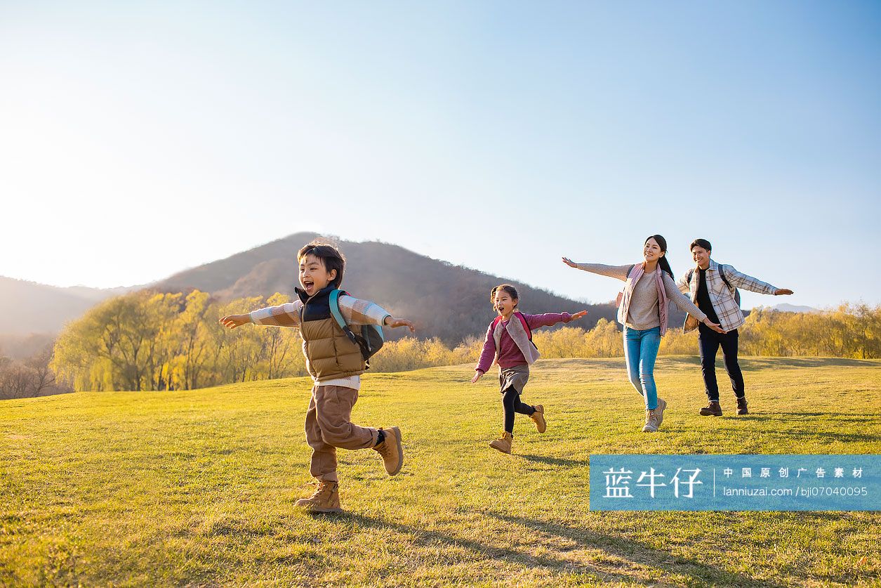 快乐的年轻家庭在草地上玩