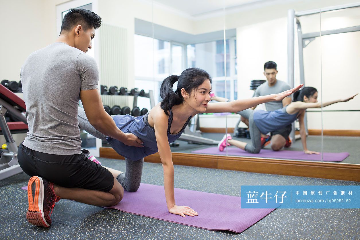 年轻女子在教练的指导下健身