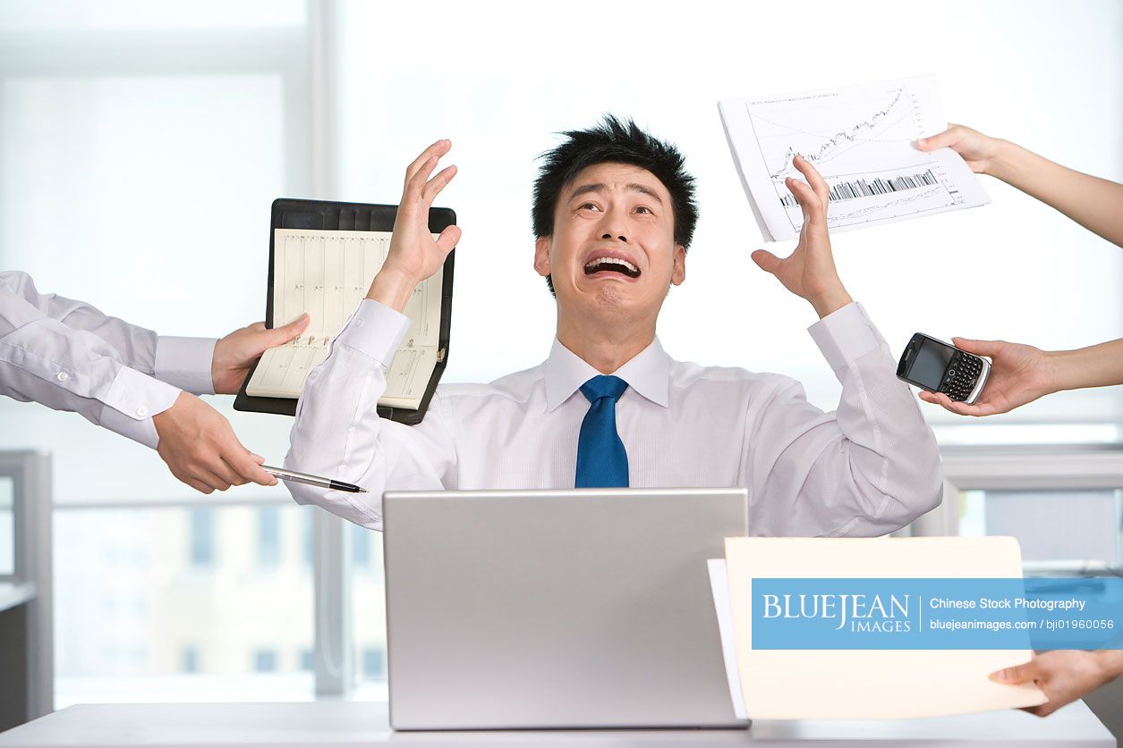 Frustrated Chinese office worker at his desk