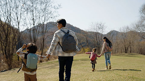 Happy young Chinese family hiking outdoors