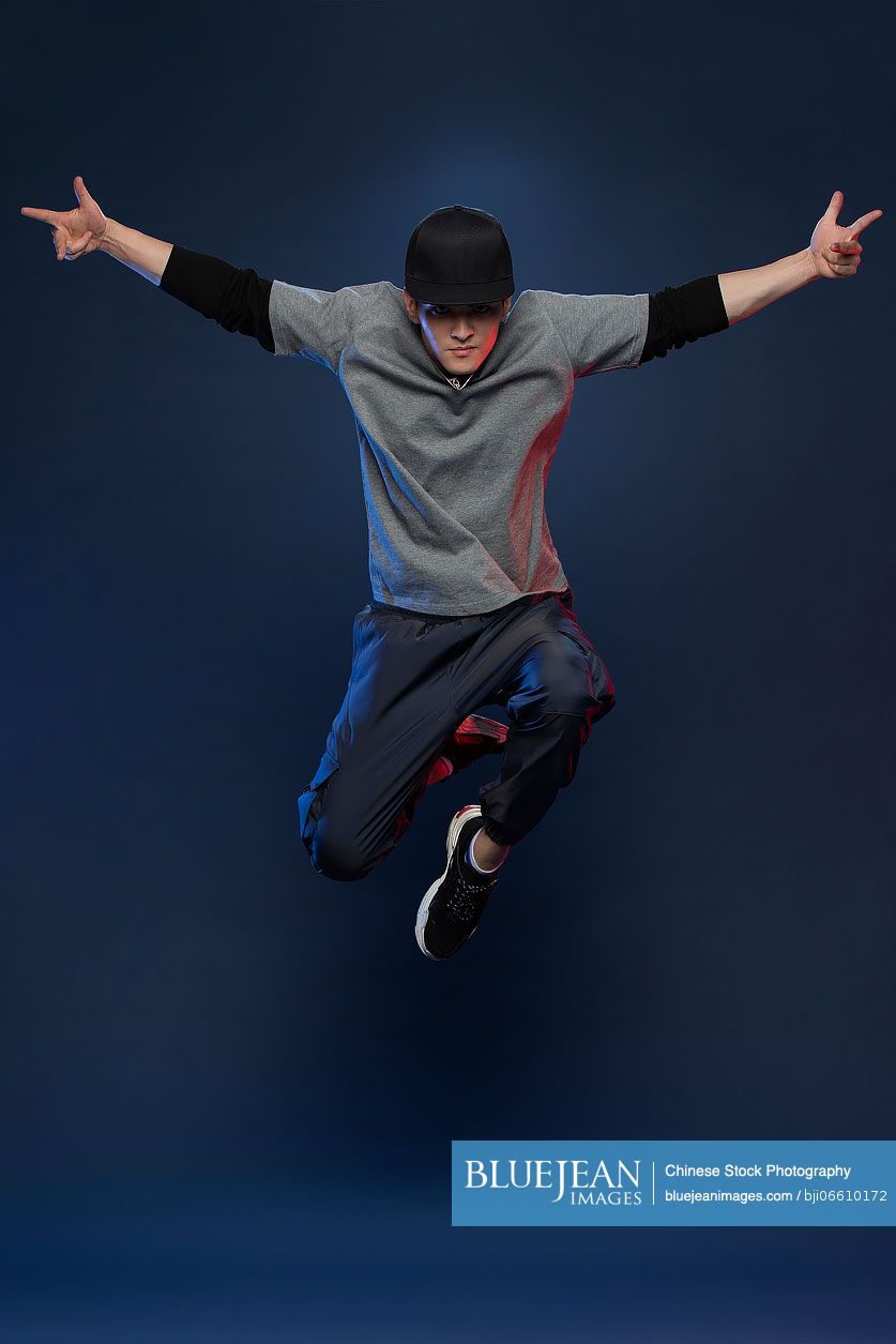 Studio shot of fashionable young Chinese man dancing