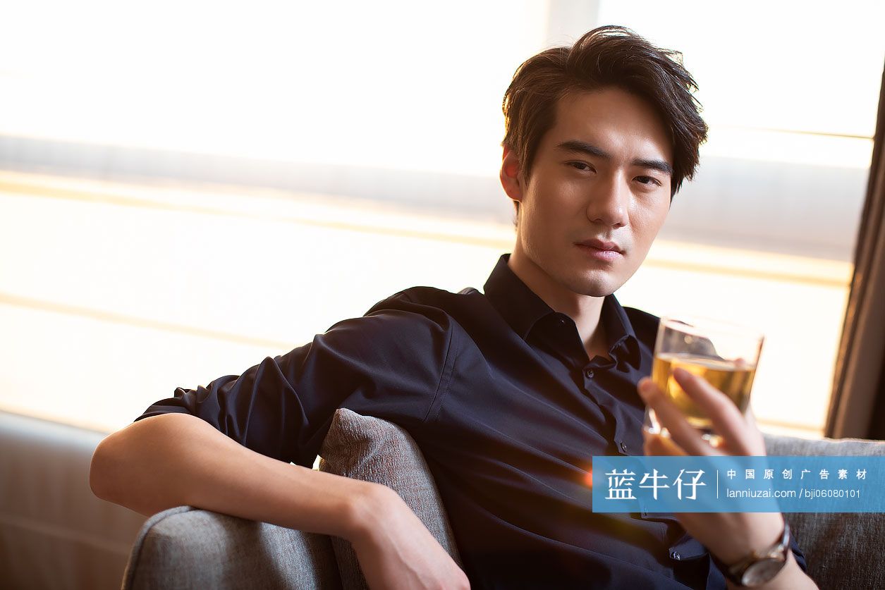 年轻商务男士在酒店房间喝酒