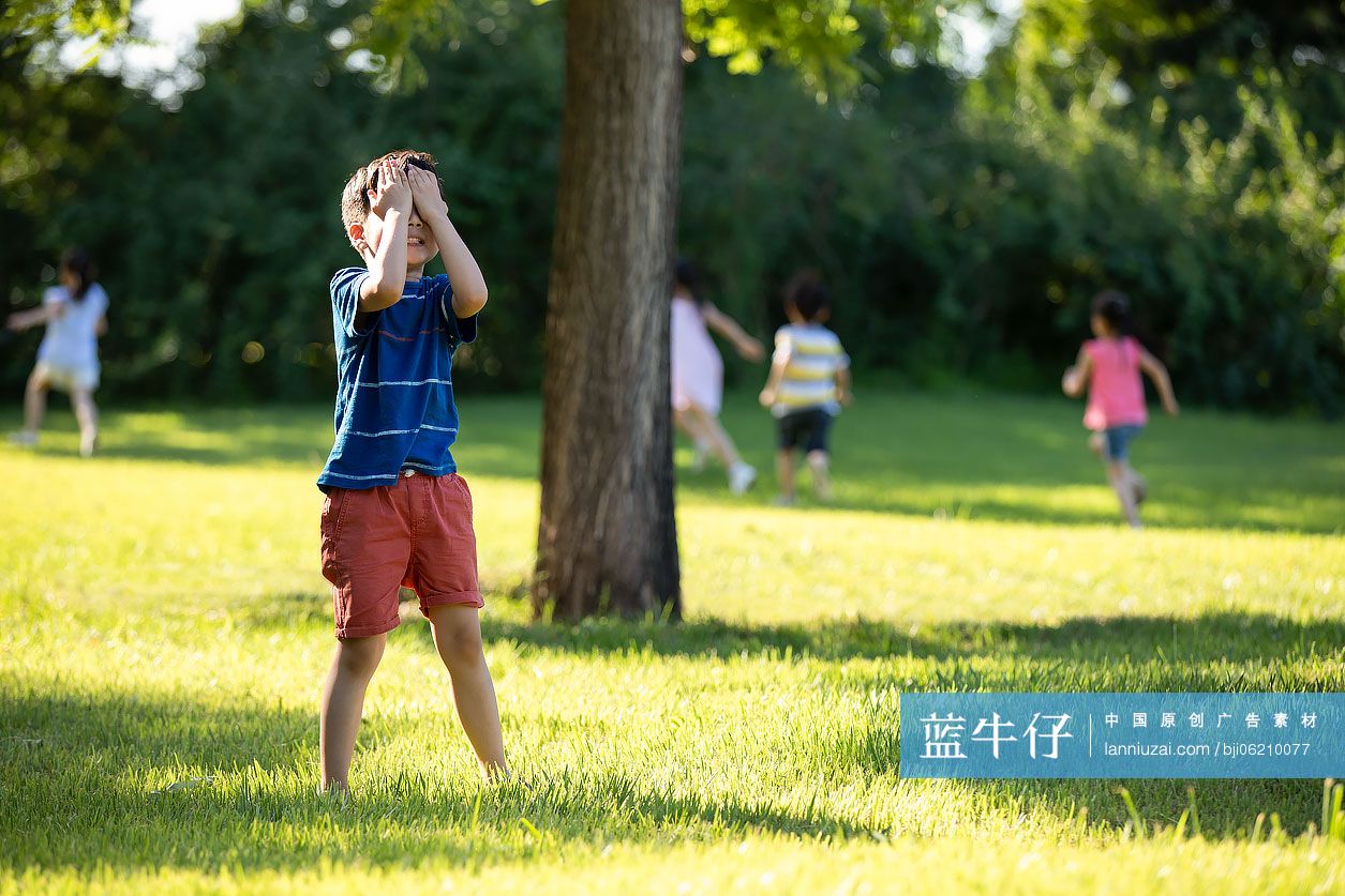 快乐的儿童在草地上玩捉迷藏