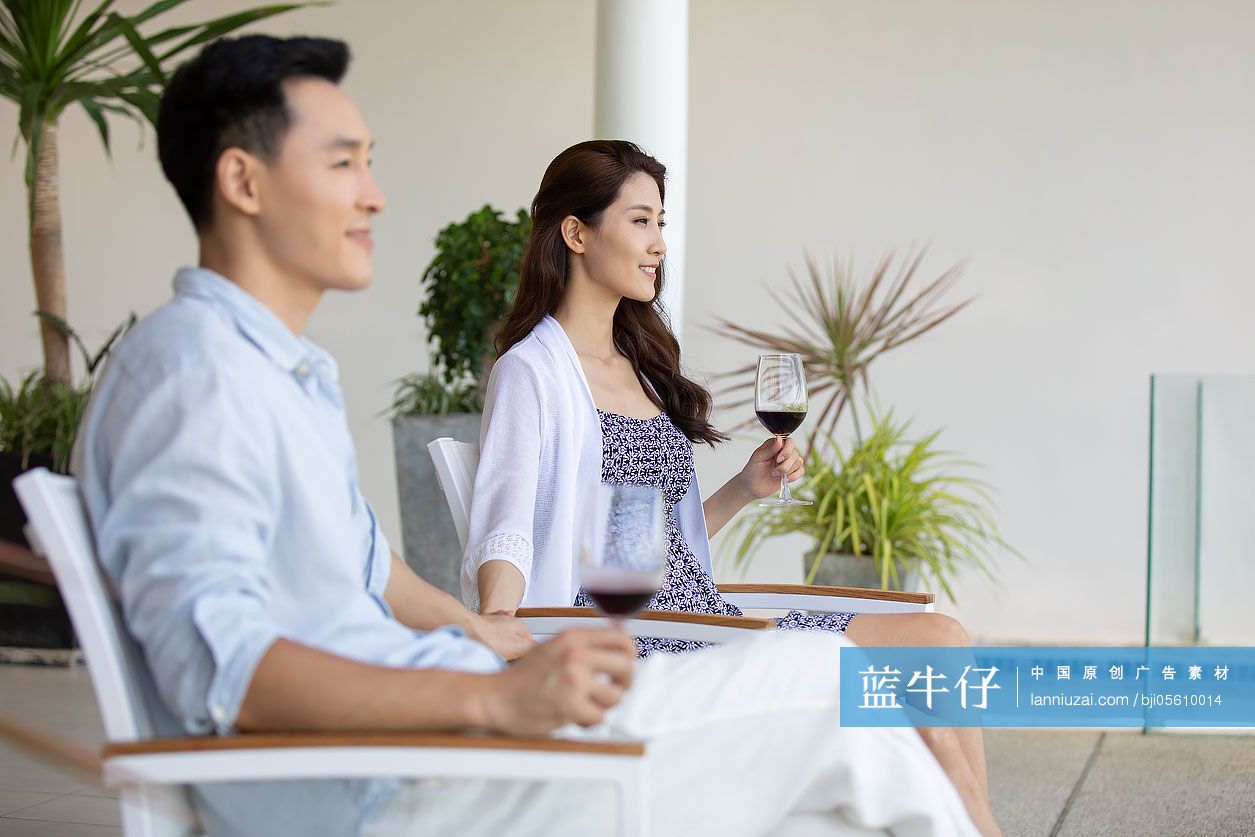 年轻夫妇在露台喝红酒