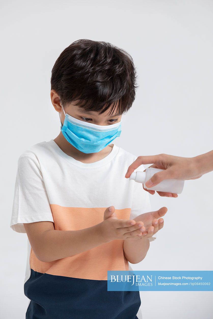 Little chinese boy using hand sanitizer high res stock photo for download