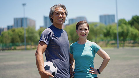 Happy Chinese couple playing football