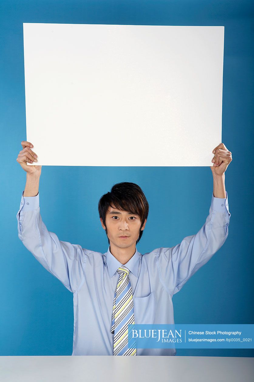 Chinese Man Holding Up Big Piece Of Paper
