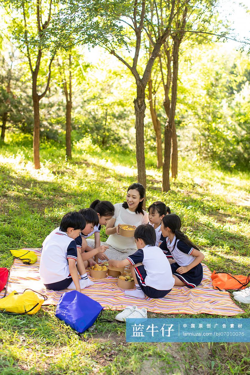 快乐的小学生和老师在户外野餐