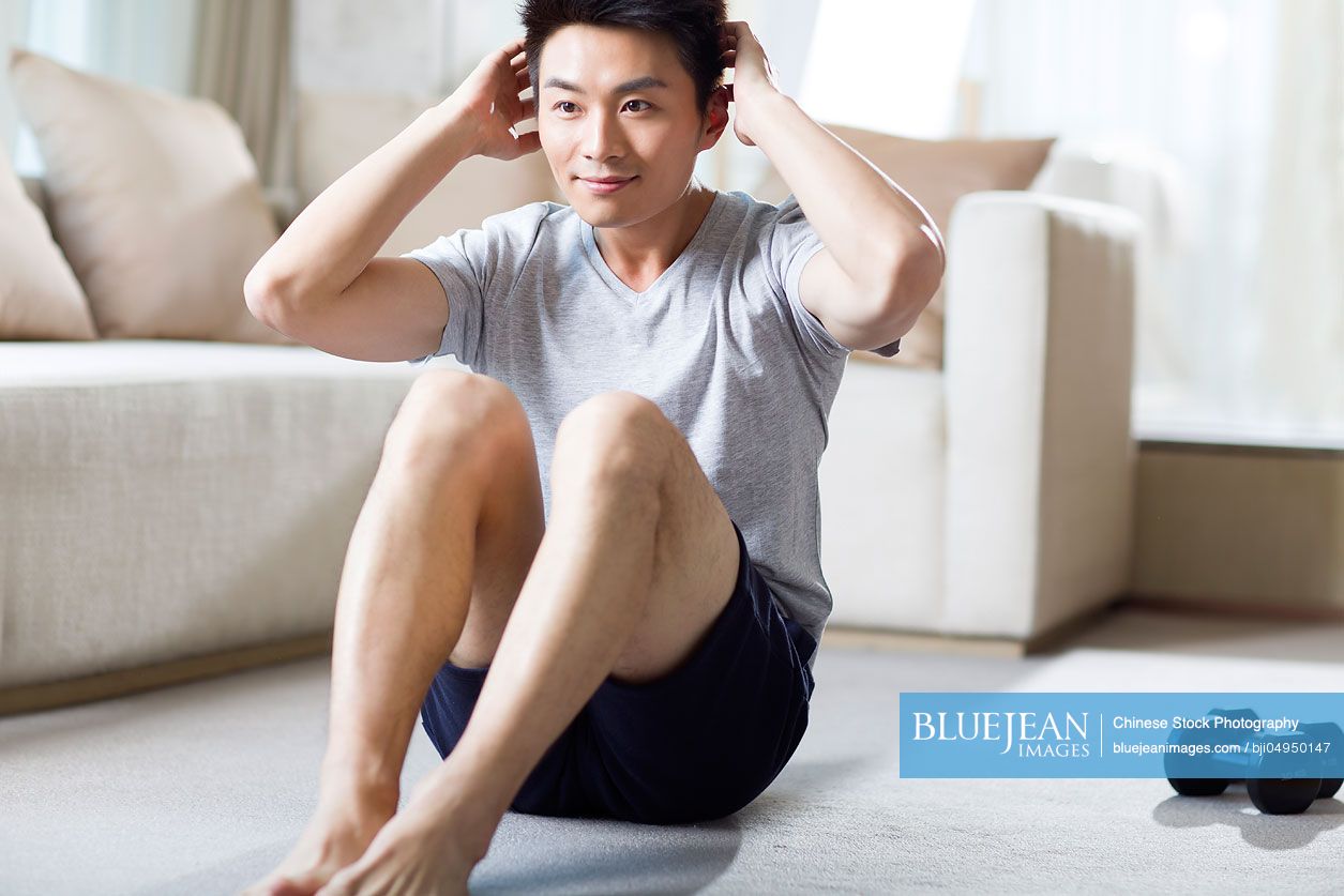 Young Chinese man exercising at home