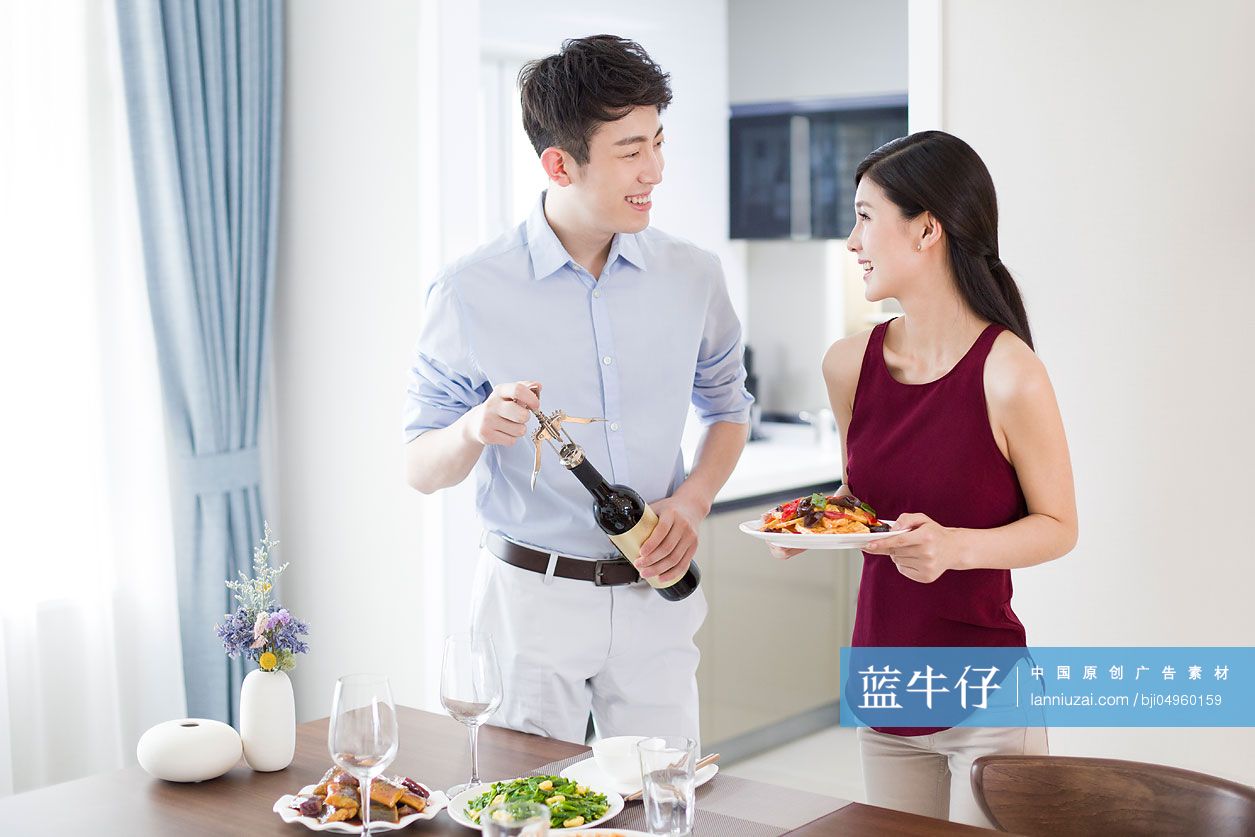 年轻夫妇摆餐桌准备吃饭