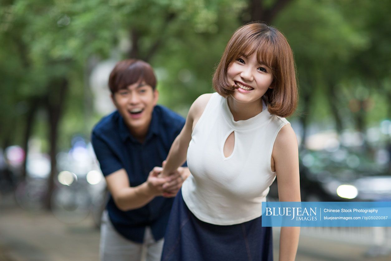 Happy young Chinese couple holding hands