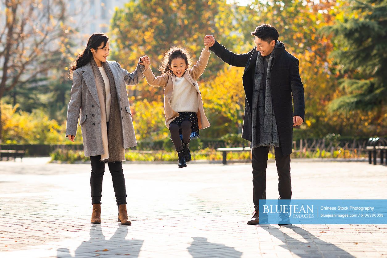 Happy young Chinese family having fun in park