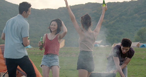 Happy young Chinese friends barbecuing outdoors,4K