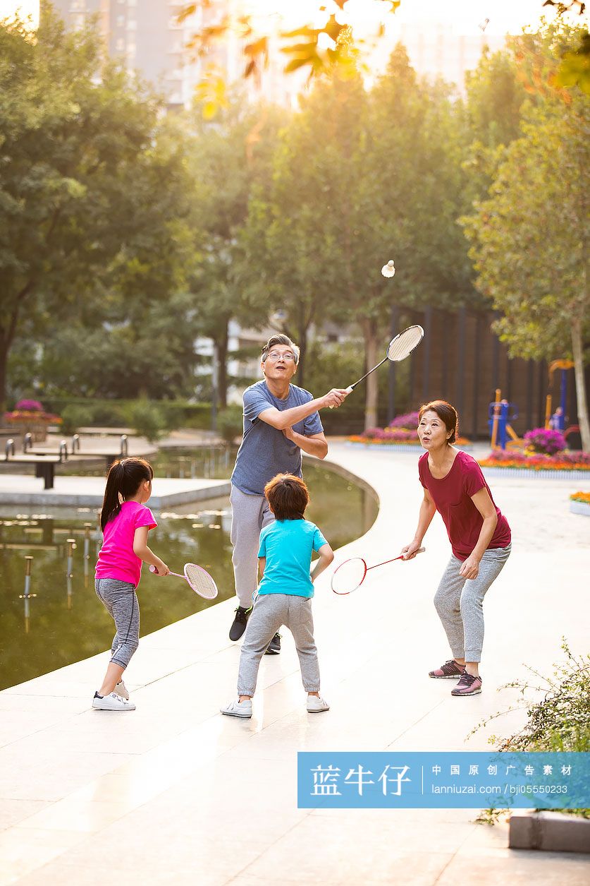 开心的一家人在公园打羽毛球