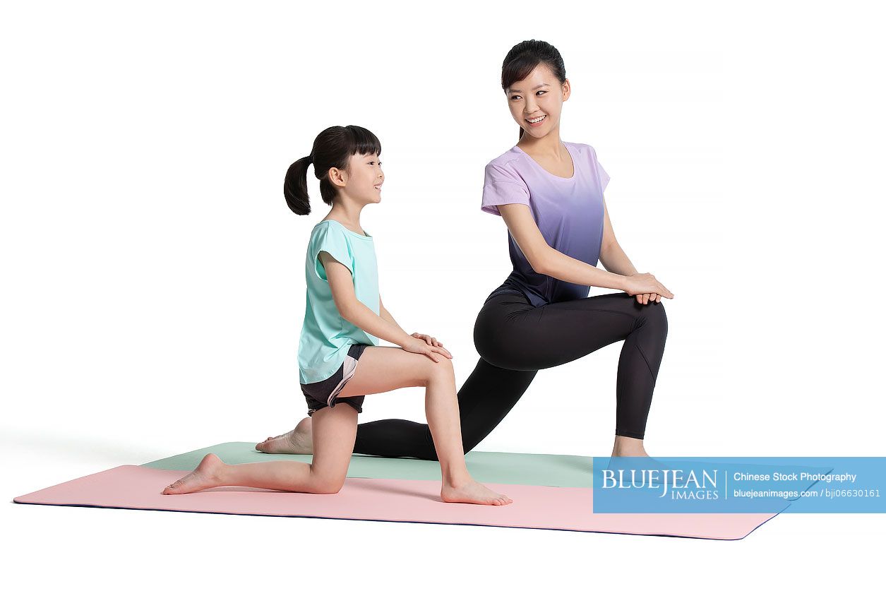 Little Chinese girl exercising with her mother