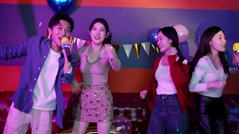 Young friends having fun at birthday karaoke party