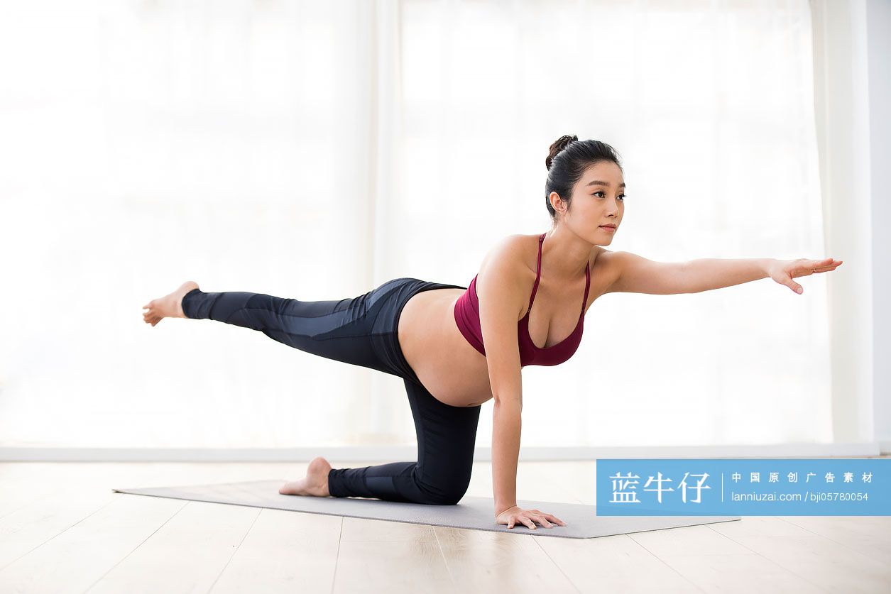 年轻孕妇在家练习瑜伽
