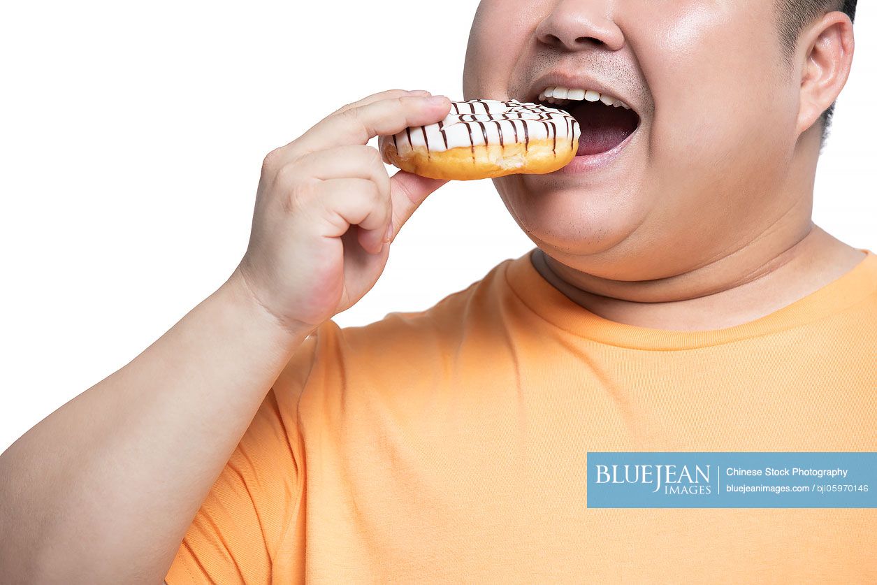 Young Chinese man eating donut
