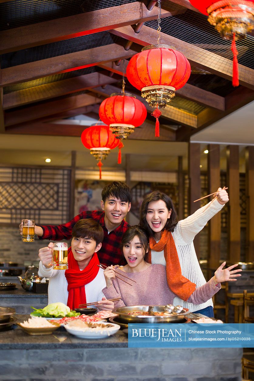 Young Chinese friends having dinner in hotpot restaurant