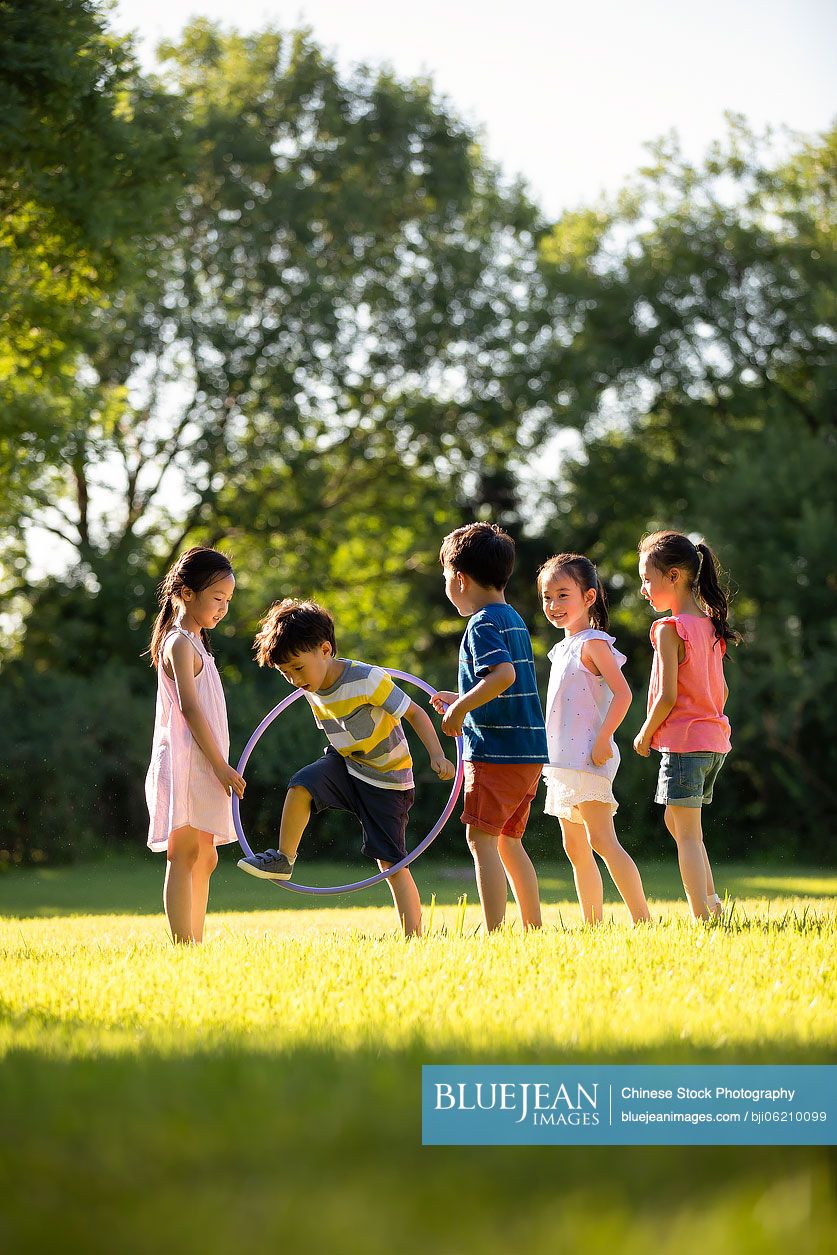 Happy Chinese children playing on meadow