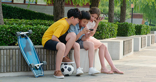 青少年在公园玩手机
