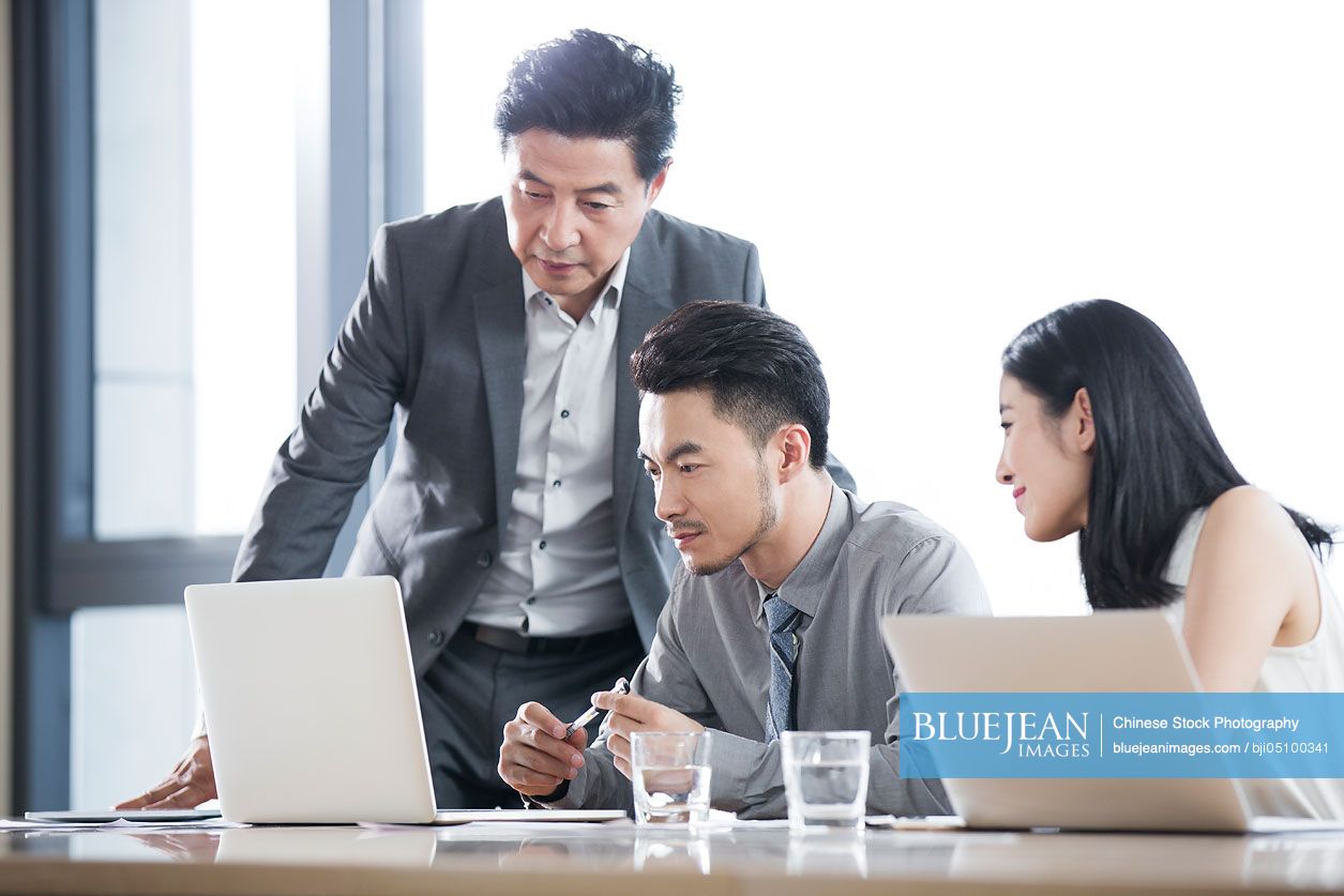 Chinese business people talking in meeting room