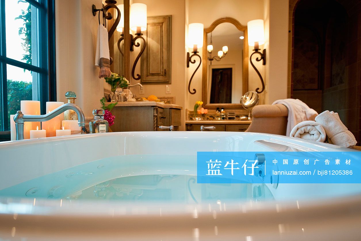 Bathtub and wall sconces in hotel bathroom