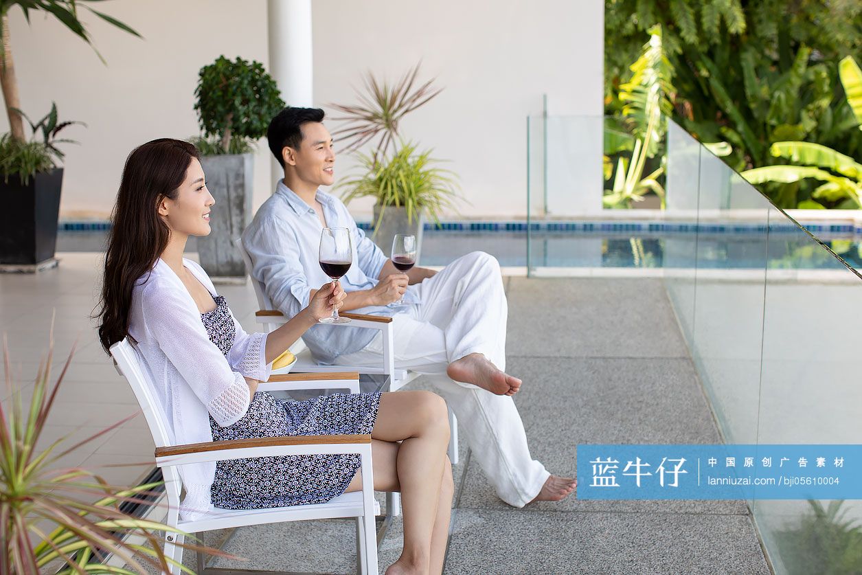 年轻夫妇在露台喝红酒