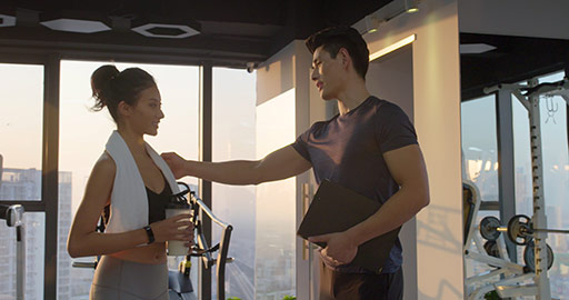 Young Chinese woman talking with personal trainer at gym,4K